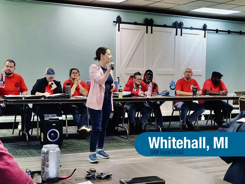 Angel Coon speaking into a microphone at a meeting in Whitehall